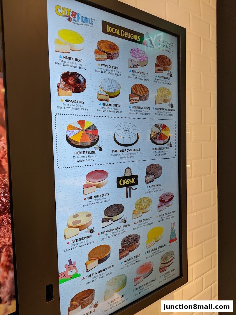 A digital menu board displaying various cheesecakes with images and prices.