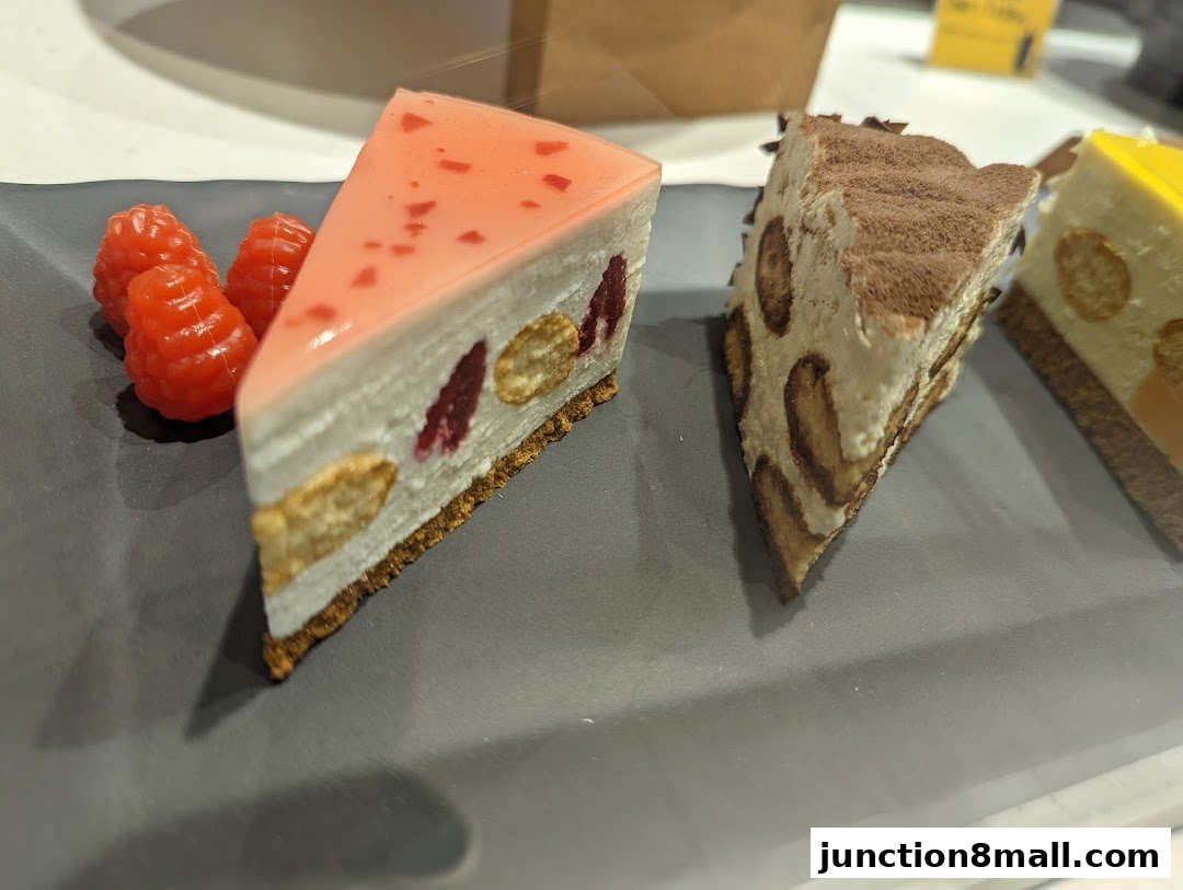 Three slices of artfully crafted cakes, including a raspberry-topped dessert and a tiramisu.