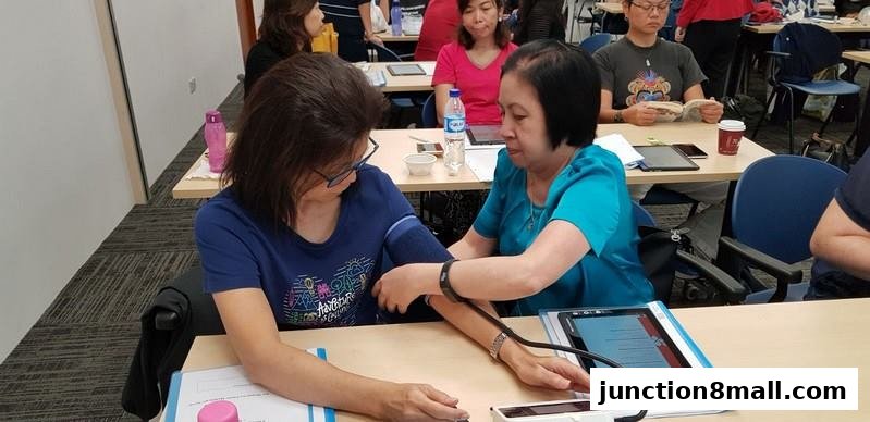 A woman checks another woman's blood pressure during a health screening event.