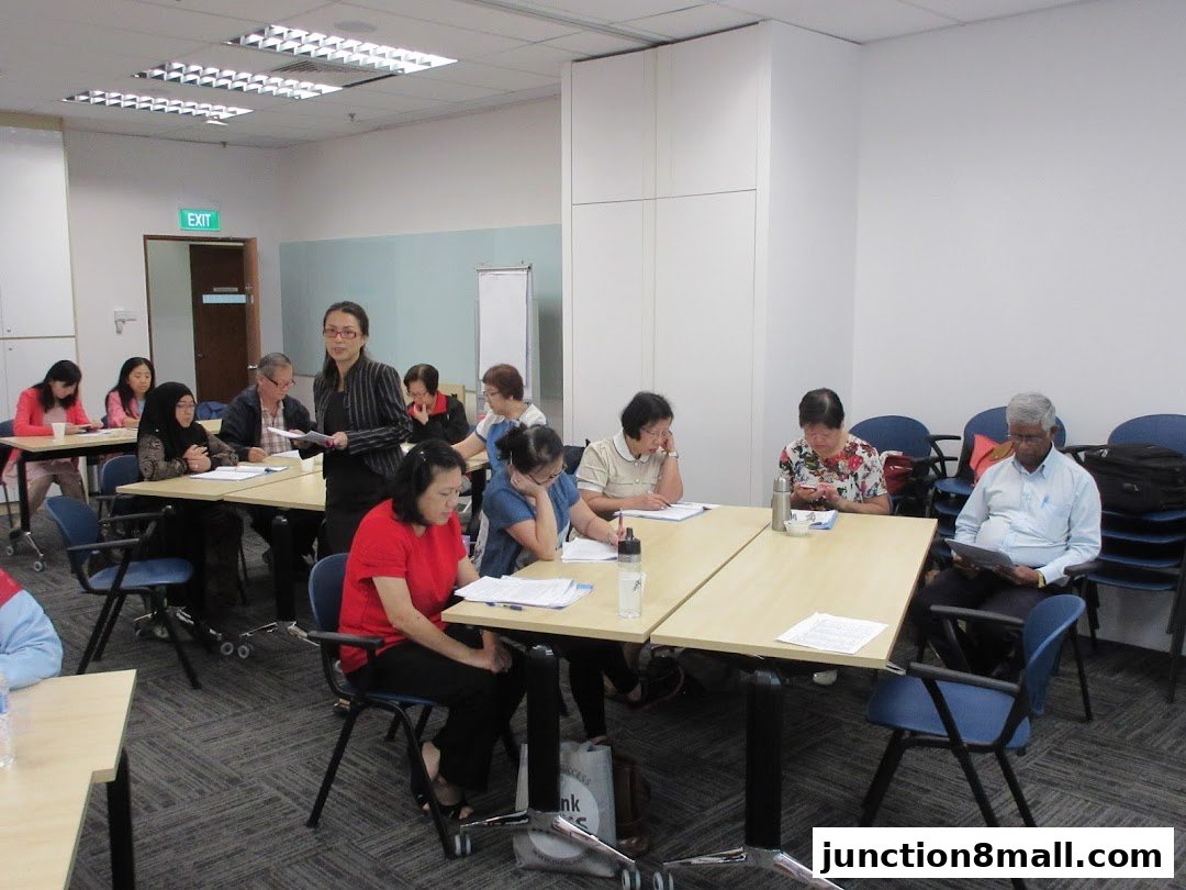 A group of seniors attending a class or seminar, with a presenter at the front.