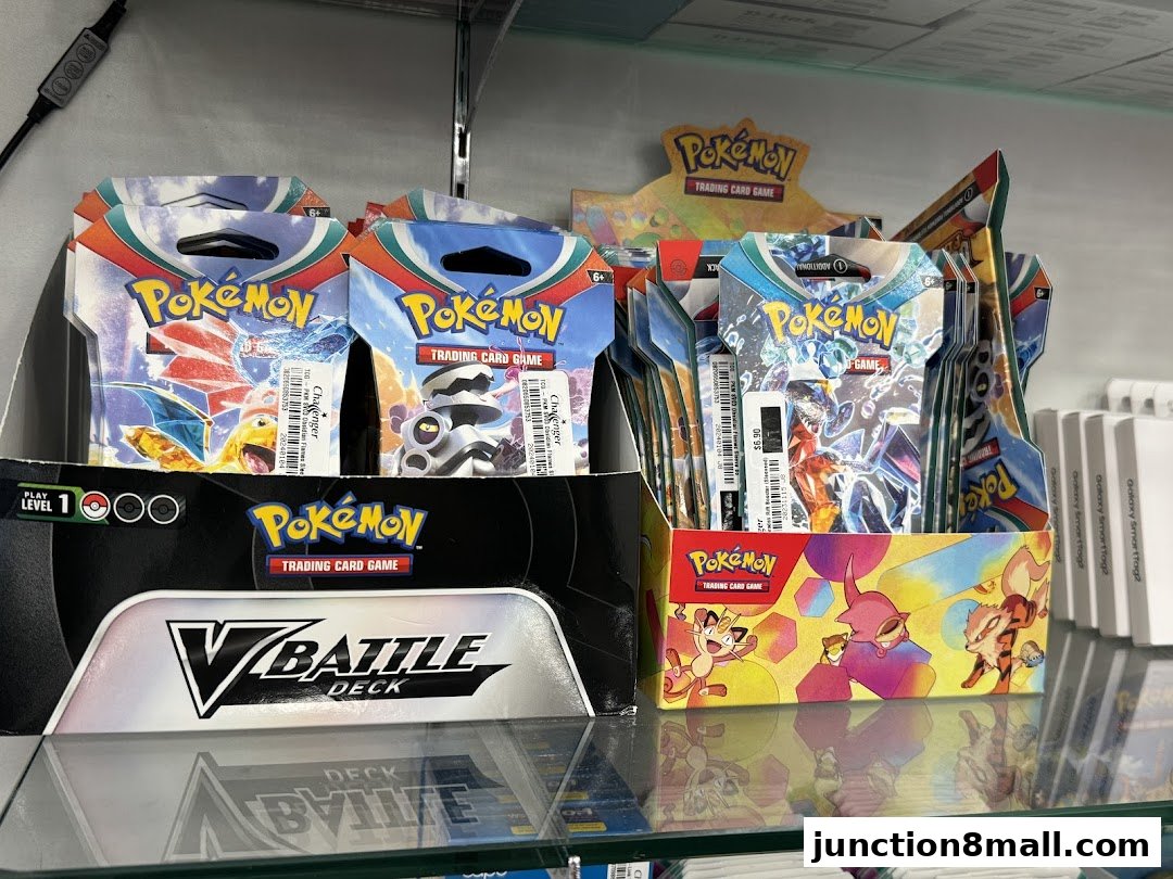Display of Pokemon trading card packs and V Battle Decks on shelves.