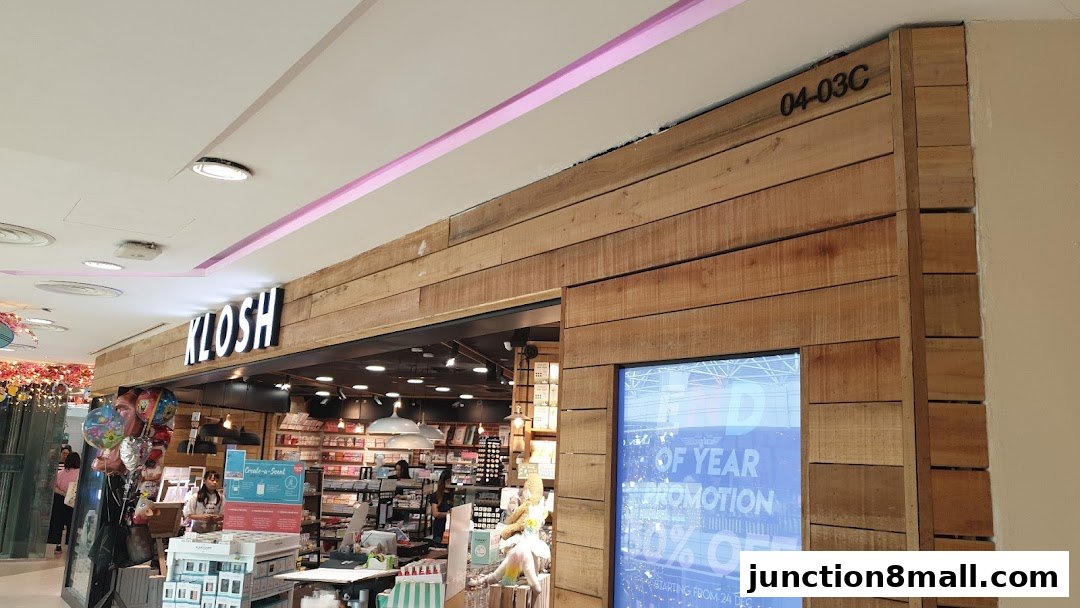 The entrance of a KLOSH store with a wooden facade and a promotional display.