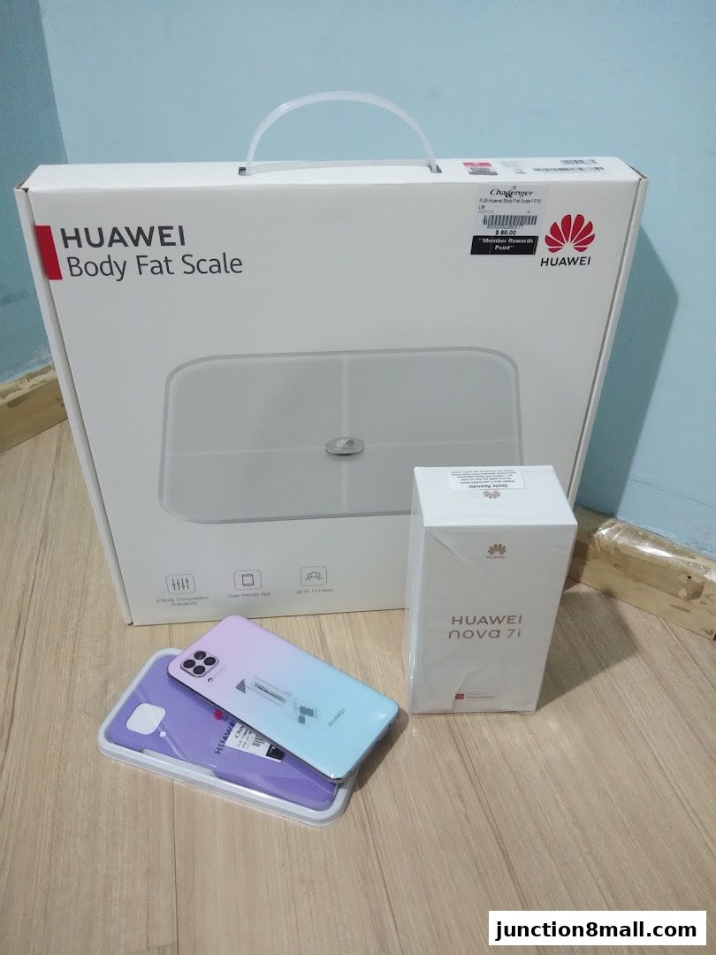 Huawei body fat scale, nova 7i phone, and a phone case displayed on a wooden surface.