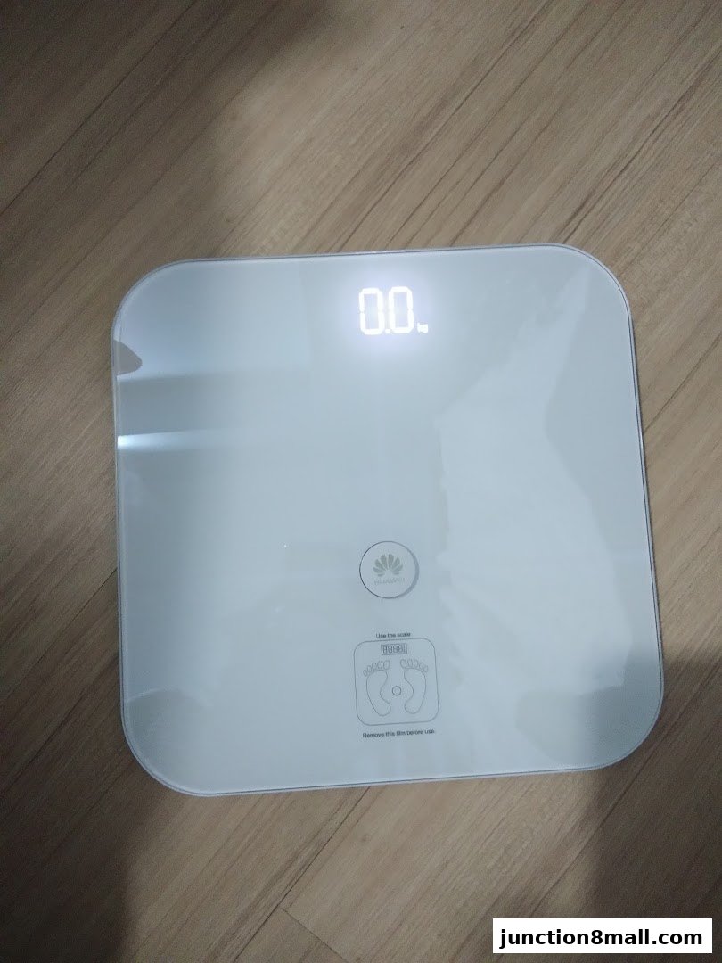A white Huawei digital scale with a display showing 0.0.