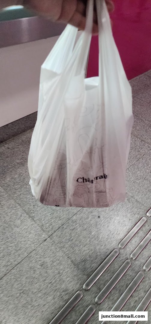 A person holding a white shopping bag with the Châteraisé logo.