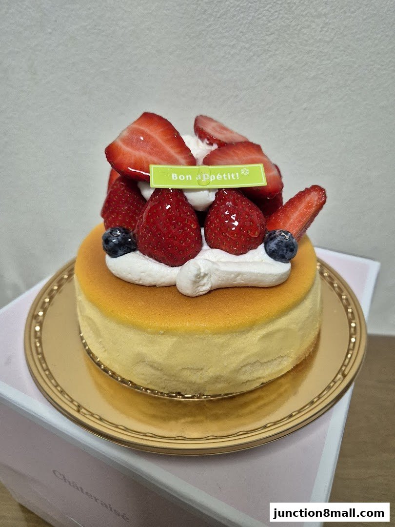 A delicious strawberry cheesecake from Châteraisé, topped with fresh strawberries and cream.
