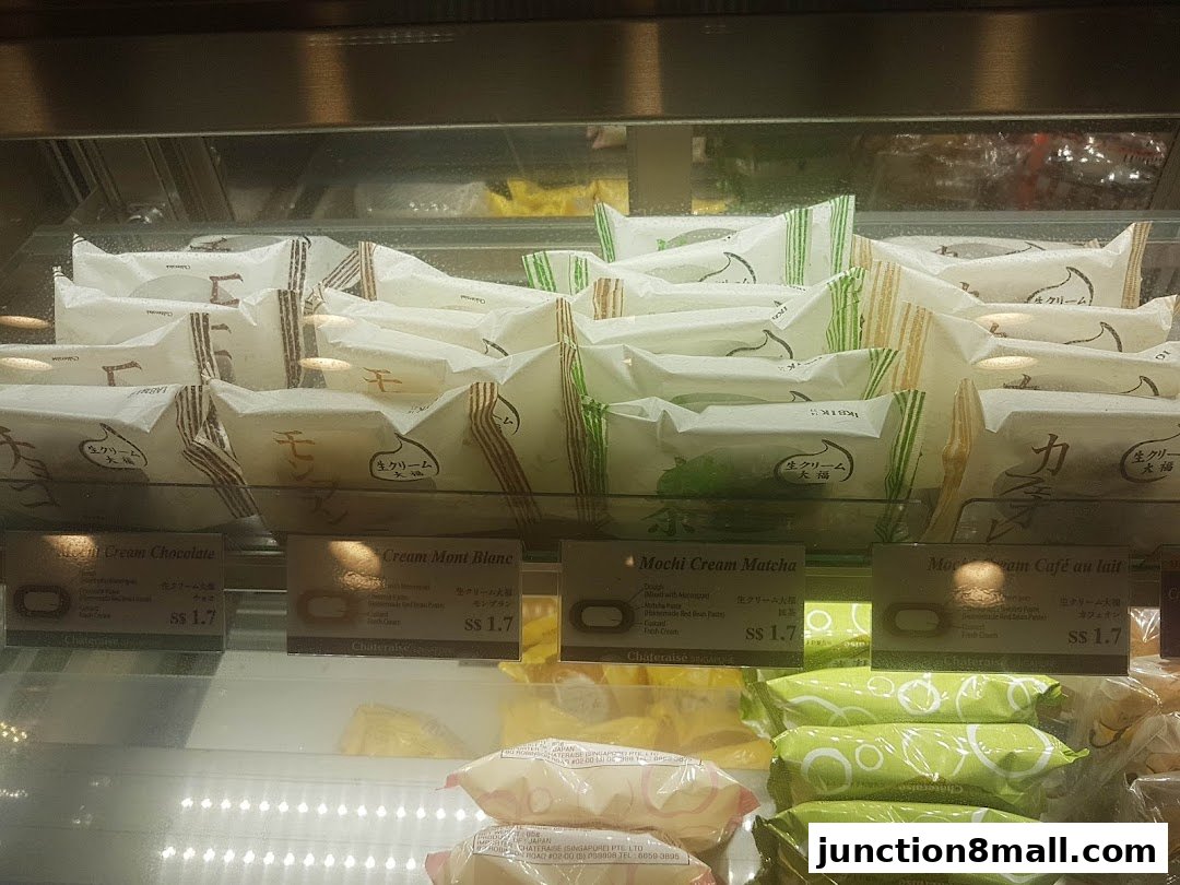 A display case filled with individually wrapped Japanese cream pastries and mochi.