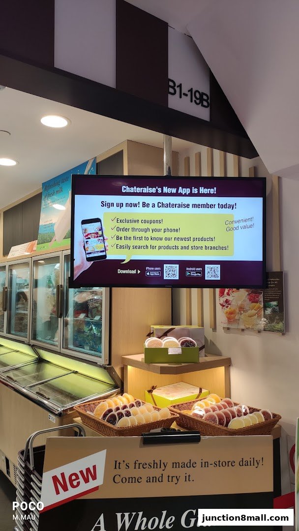 A Chateraise store interior featuring a promotional screen for their new app and displays of fresh pastries.