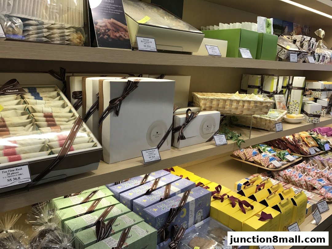 A display of beautifully packaged sweets and baked goods on shelves in a retail store.