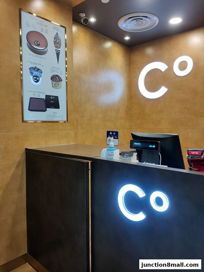 The counter and menu of a Chocolate Origin shop with illuminated logos.