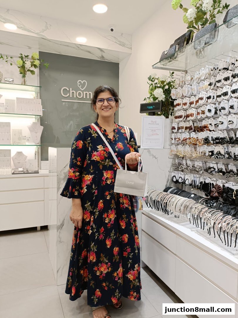 A woman smiles in a brightly lit shop displaying hair accessories and jewelry.