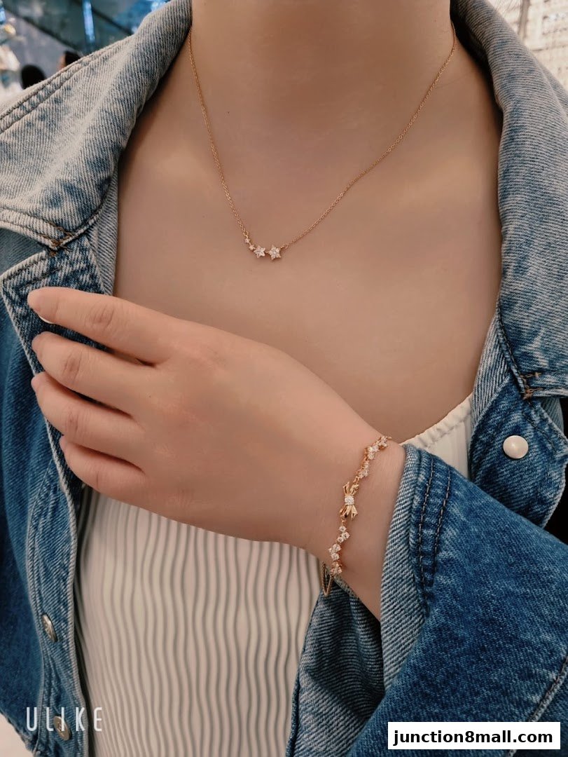 A person wearing a delicate star-themed necklace and bracelet from Chomel.