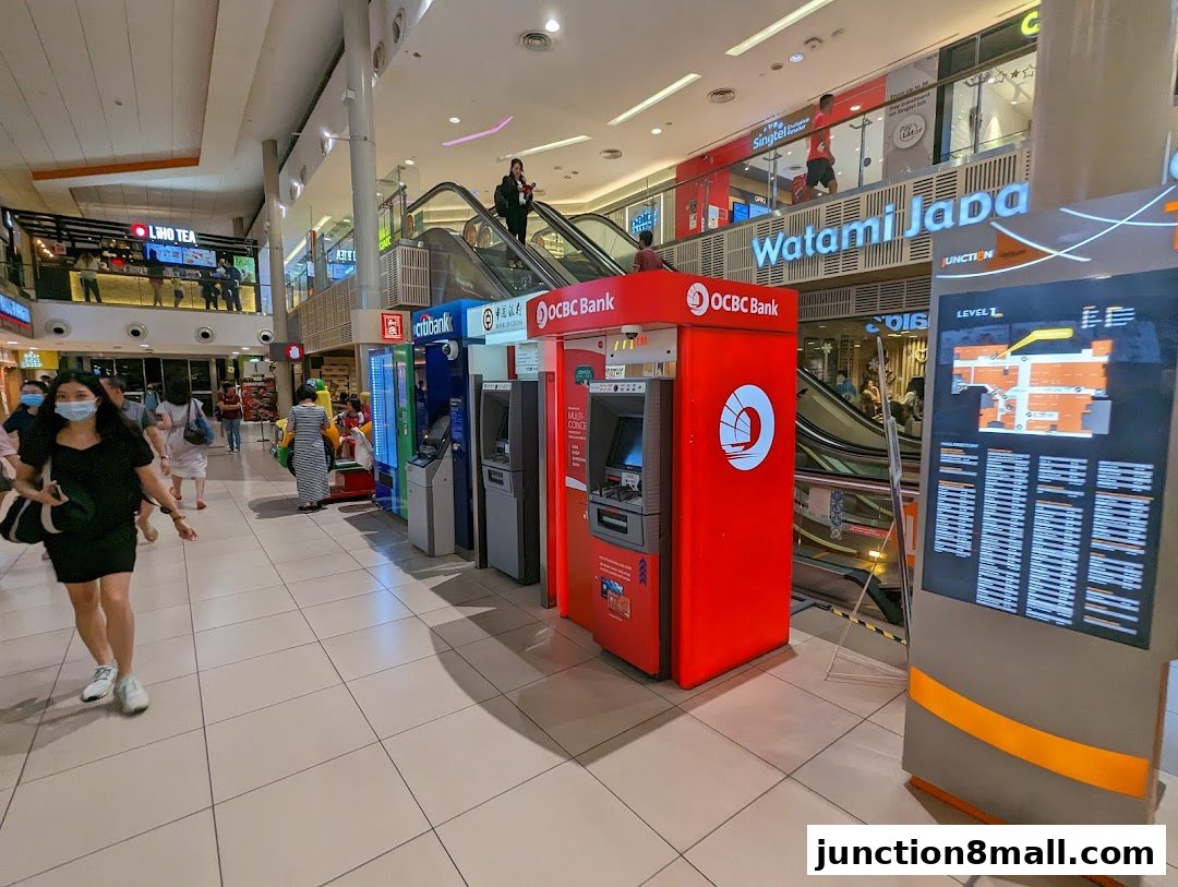 Various bank ATMs and a mall directory are visible in a shopping mall corridor.