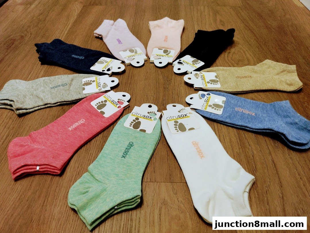 A colorful assortment of Citrusox ankle socks arranged in a circle on a wooden surface.