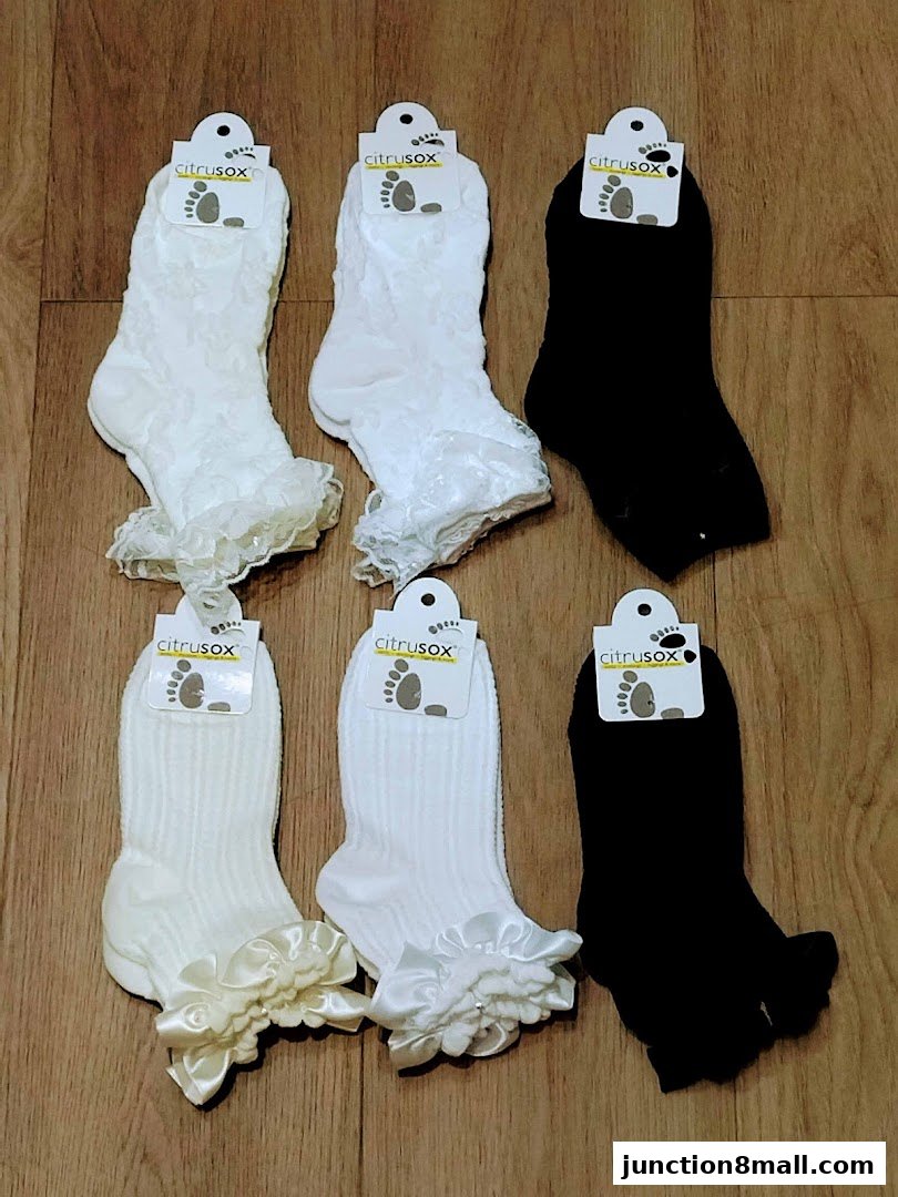 A collection of six pairs of socks in white and black, featuring lace and satin embellishments.