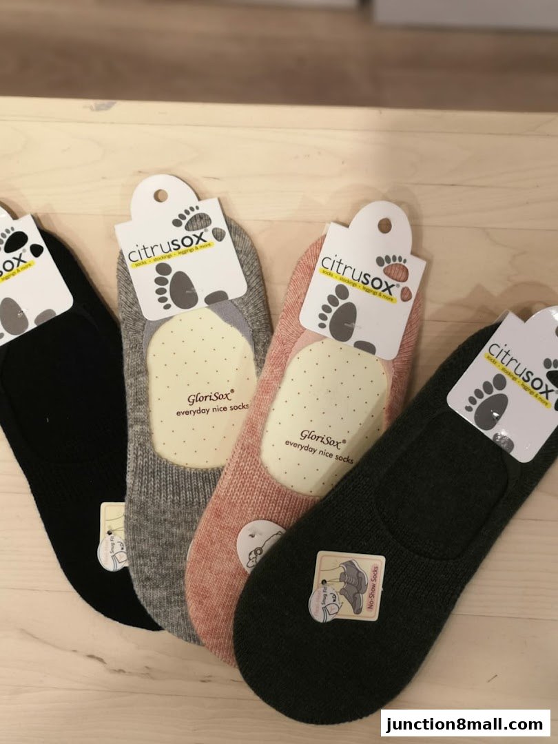 A display of four pairs of no-show socks in black, grey, pink, and dark green.
