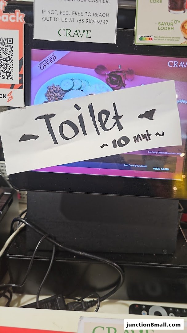 A sign indicating a 10-minute wait for the toilet at Crave Nasi Lemak.
