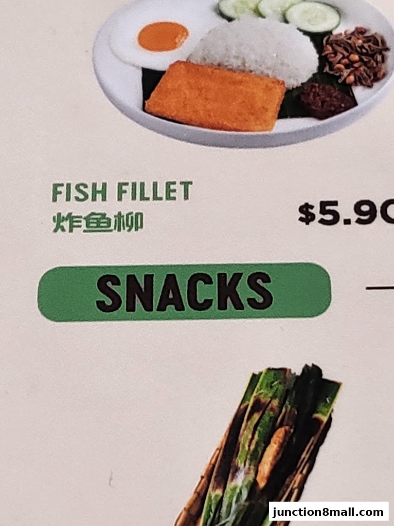 A close-up of a Nasi Lemak dish with fish fillet and a 'Snacks' category label.