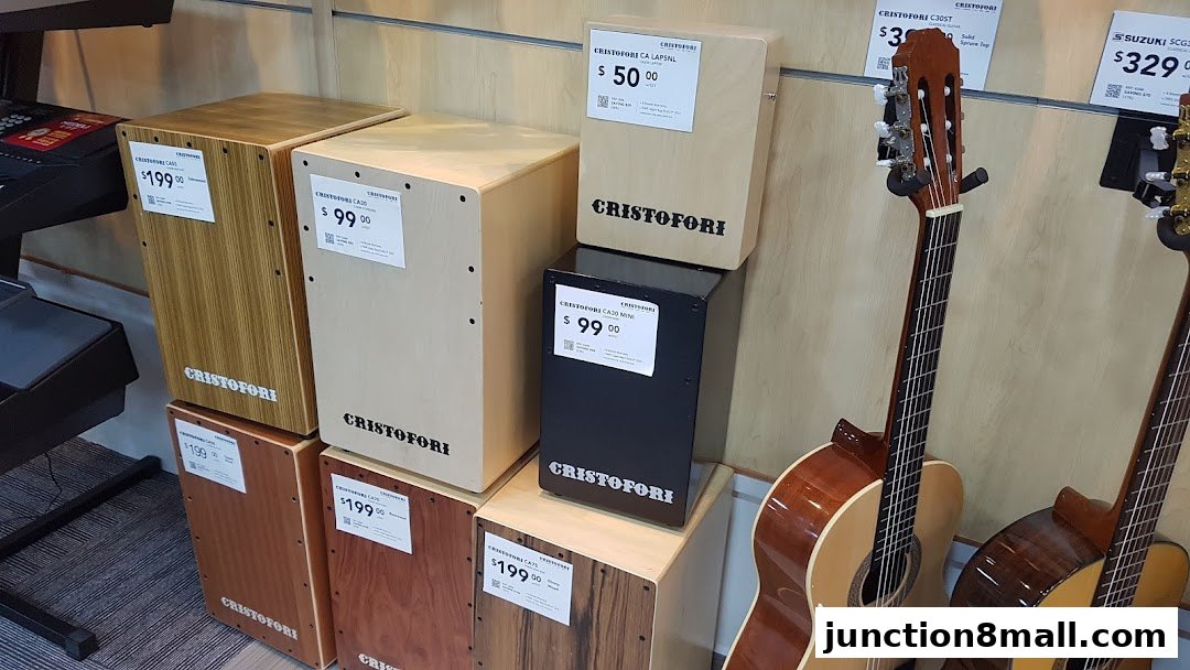 A display of various musical instruments, including cajons and guitars, with price tags.