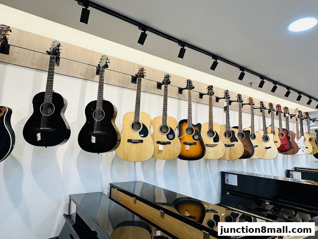 A wall display of acoustic and electric guitars, with pianos in the foreground.