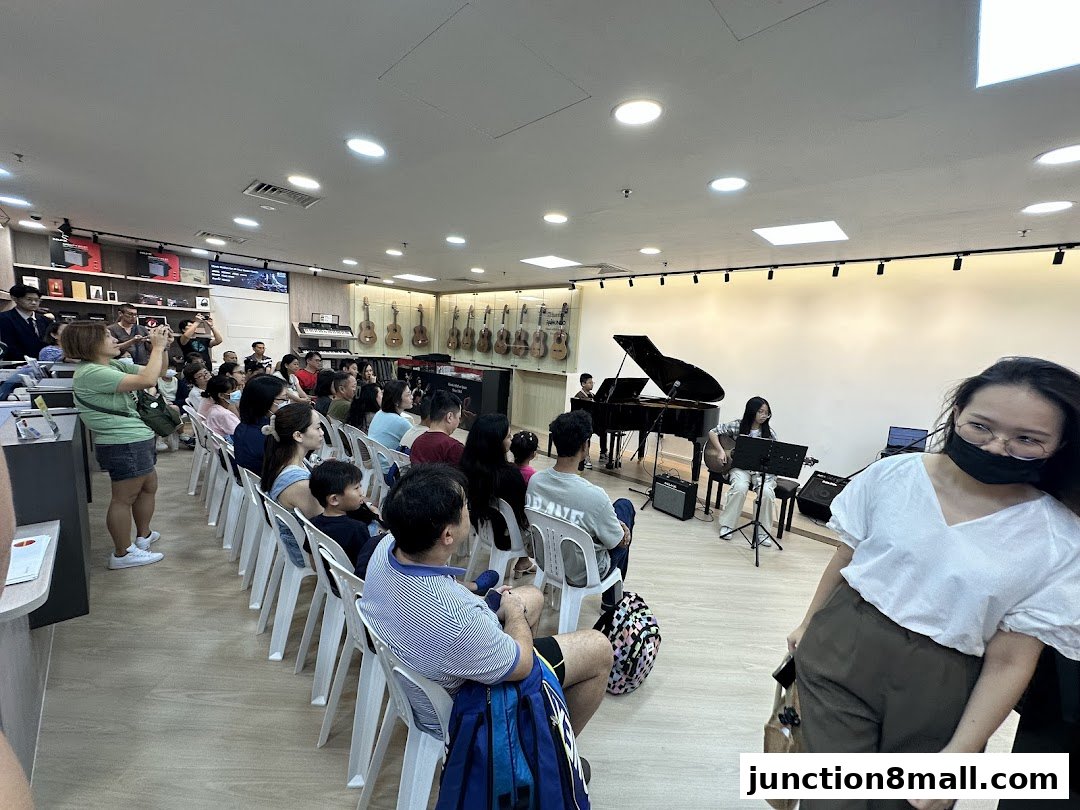 A music school event with students performing and an audience watching.