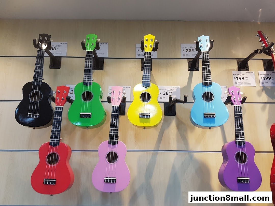 A display of colorful ukuleles of various sizes and colors, some with price tags.