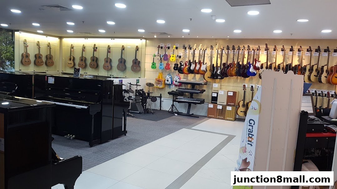 Interior view of a music store showcasing pianos, guitars, and drum sets.