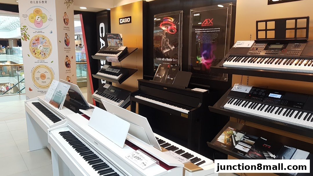 A display of Casio digital pianos and keyboards, with educational charts on the side.