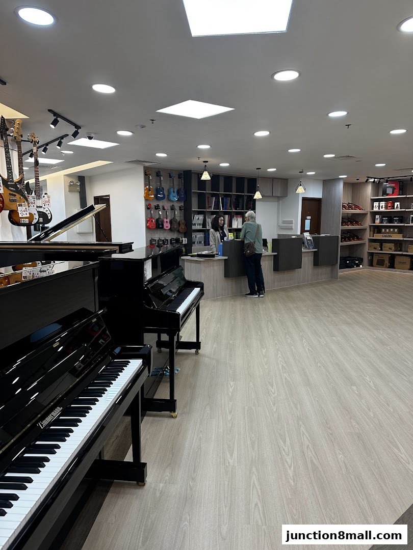 Interior of a music school with pianos, guitars, and staff assisting a customer.