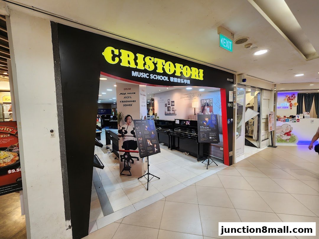 The entrance to Cristofori Music School, showcasing pianos and music-related brands.