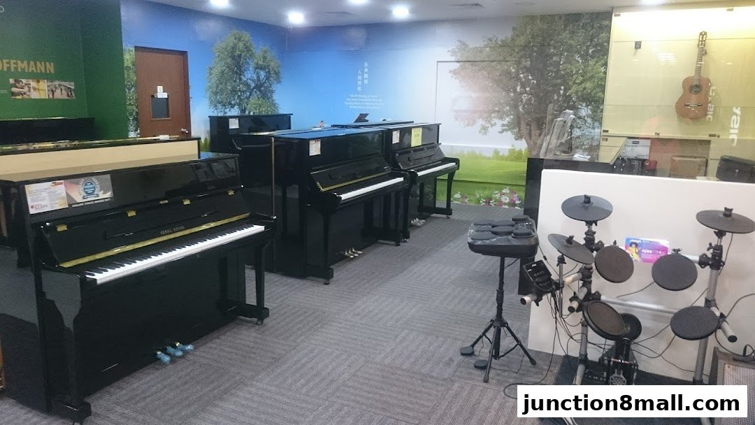 Interior of a music school with pianos and an electronic drum set on display.