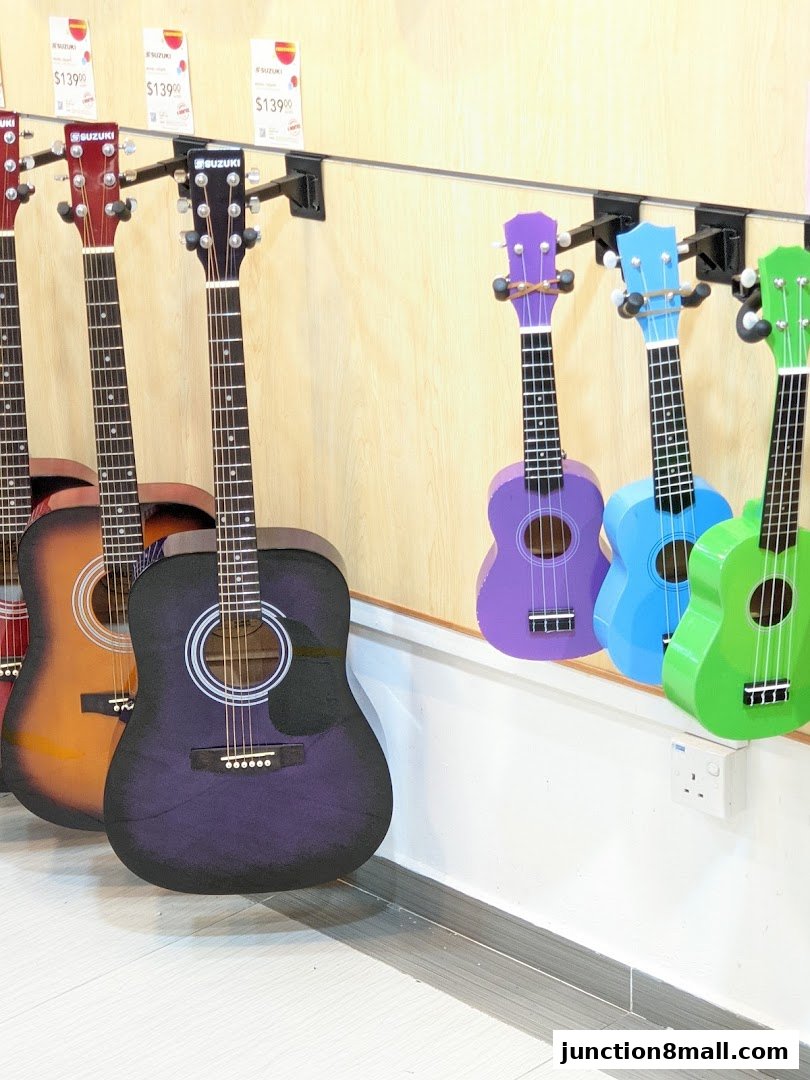 A display of guitars and ukuleles in various colors, some with price tags.