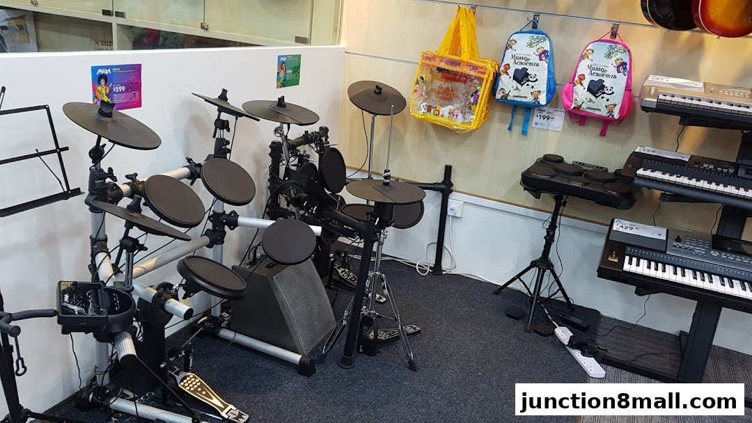 Interior view of a music school showcasing electronic drum kits and keyboards.