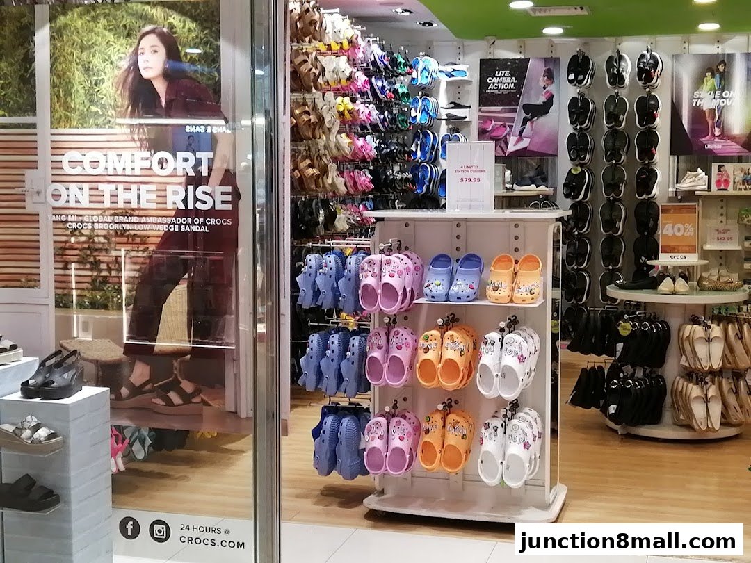Interior view of a Crocs store showcasing a wide variety of colorful sandals and shoes.