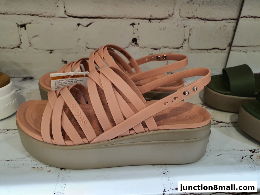 A pair of peach-colored Crocs sandals with a platform sole are displayed.
