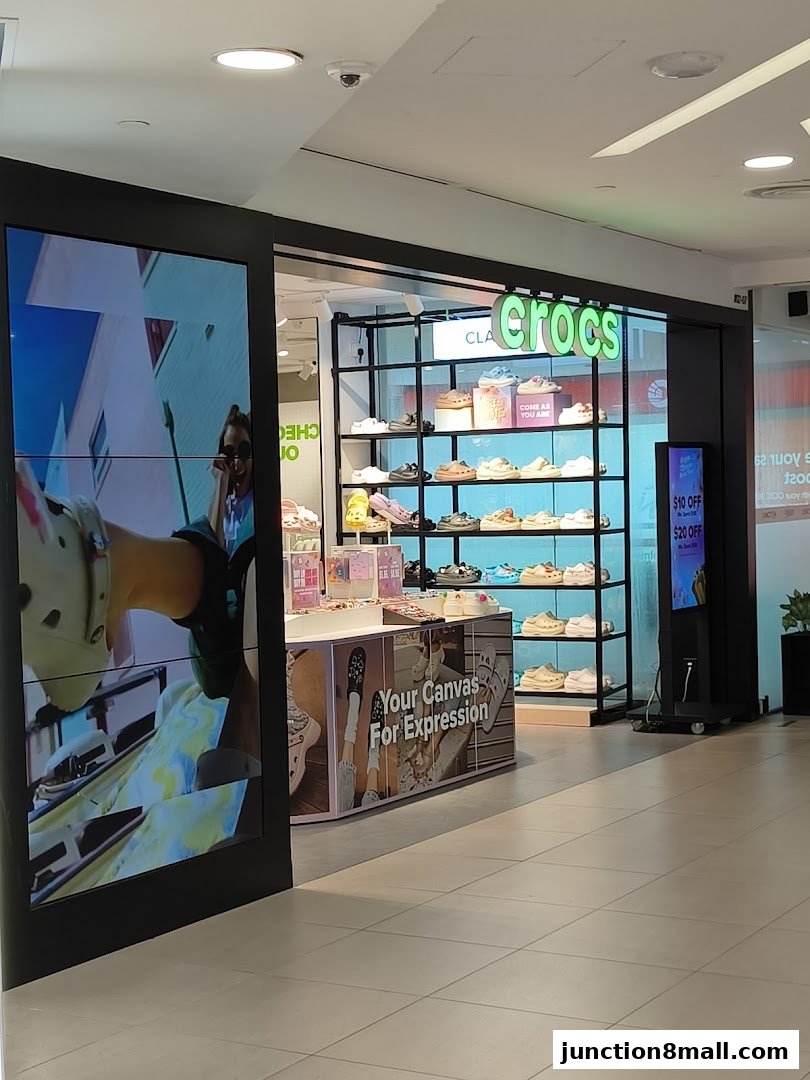The Crocs store features a display of colorful clogs and a large screen showing lifestyle imagery.