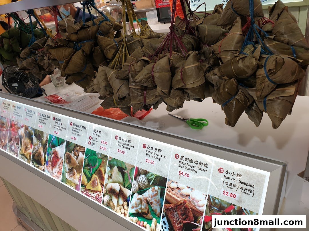 A display of various rice dumplings with their names and prices, hanging from the ceiling.