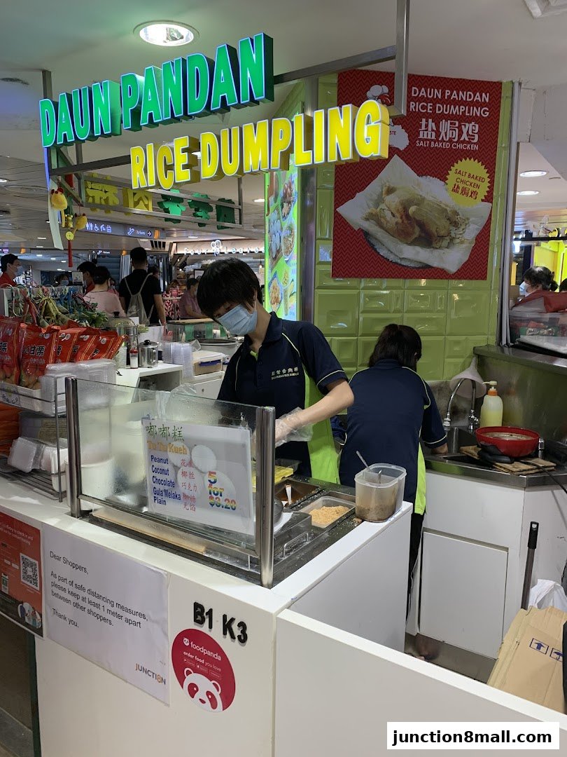 A food stall named Daun Pandan Rice Dumpling with staff preparing food and a menu displayed.