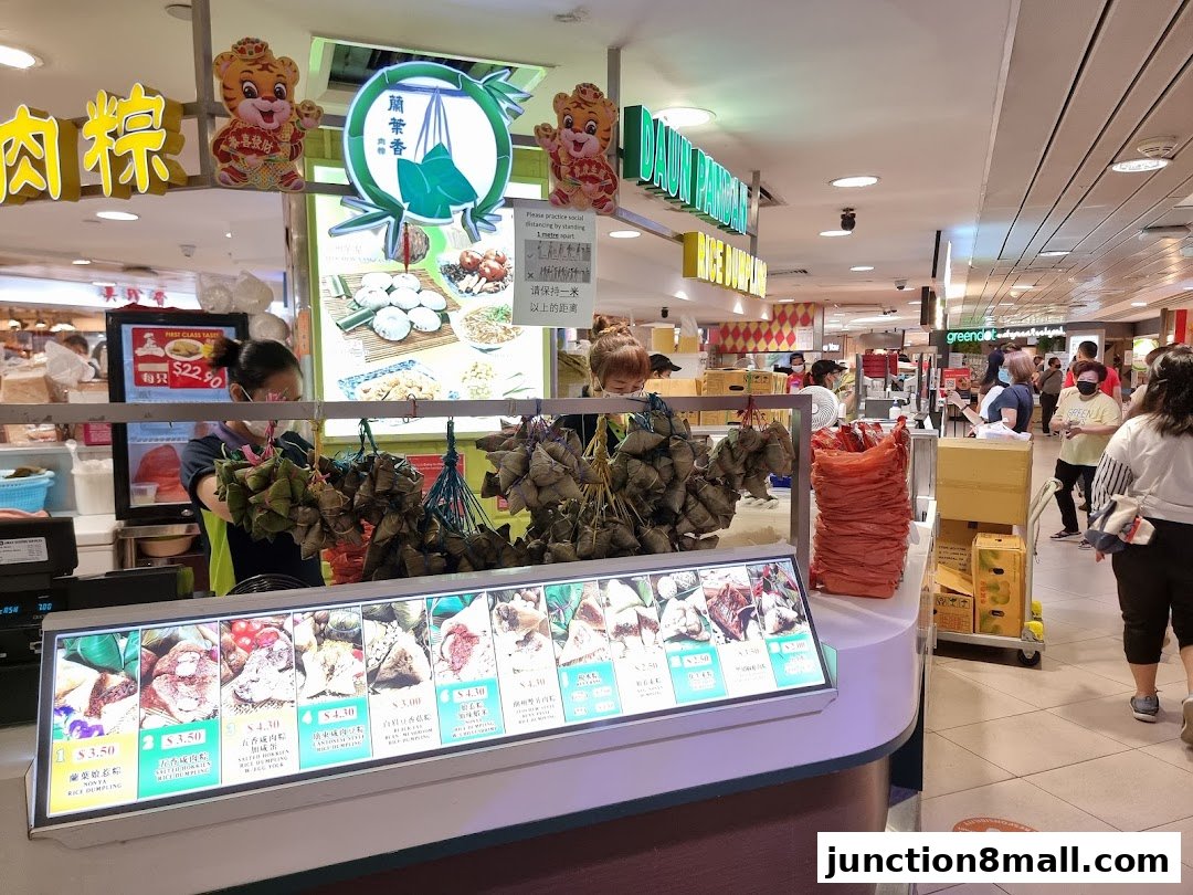 A food stall selling various types of rice dumplings with a display of their products and prices.
