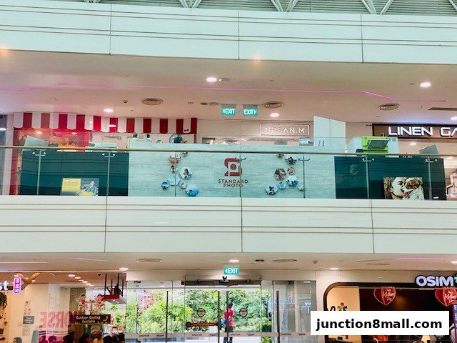 A view of a shopping mall interior showing various shops and escalators.