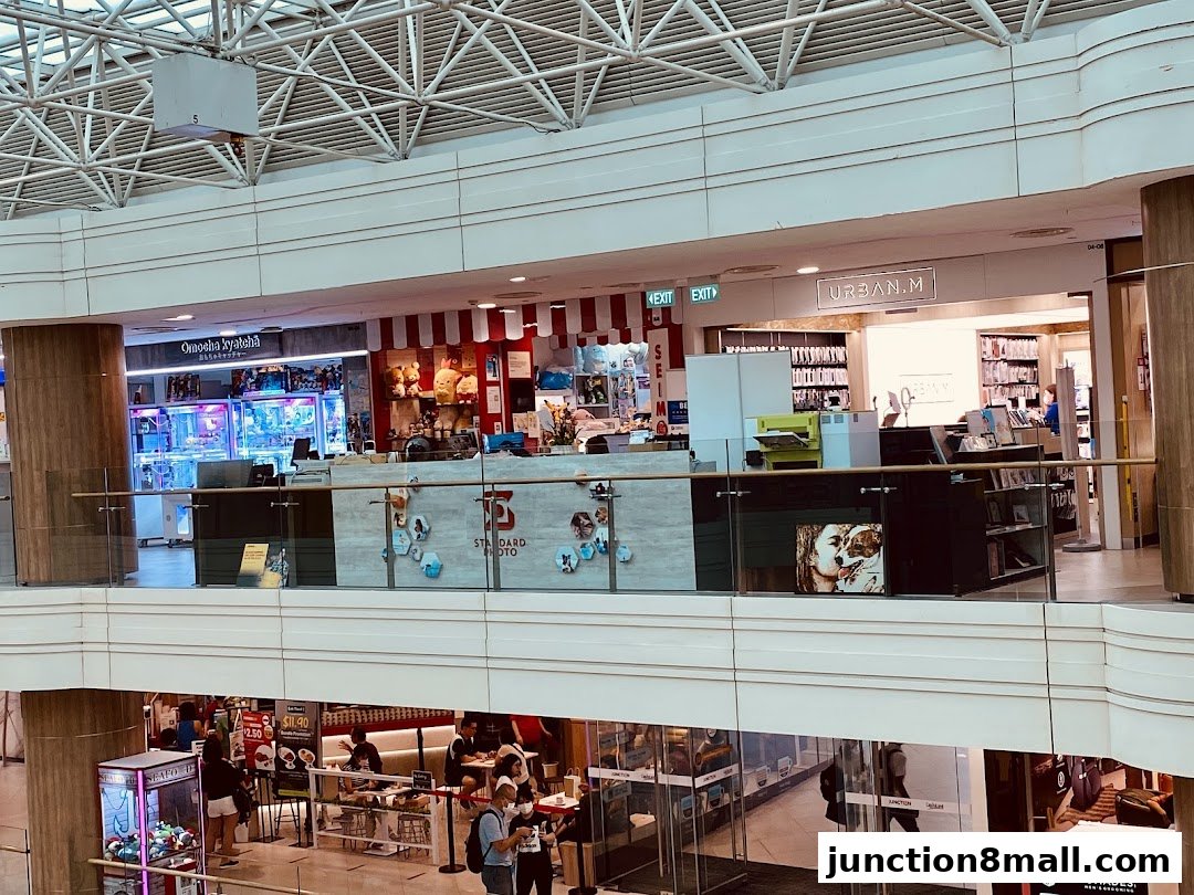 A view of various shops on the second floor of a mall, including a DHL service point.