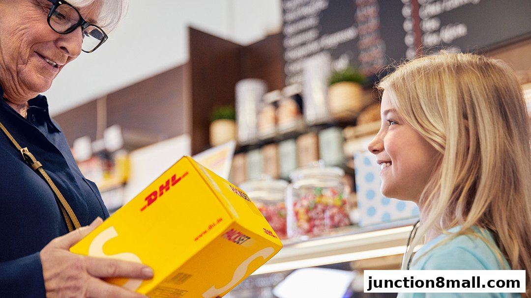 A woman hands a DHL package to a smiling girl in a store.