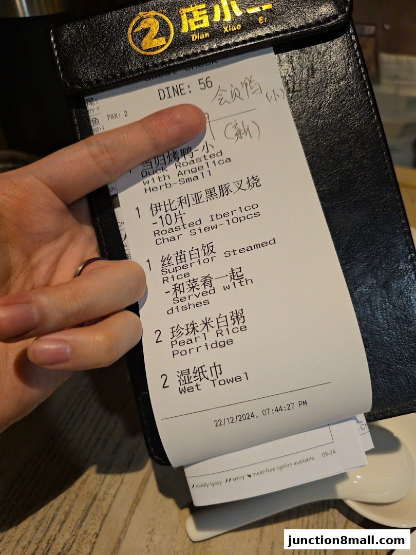 A close-up of a restaurant receipt showing ordered dishes and wet towels.