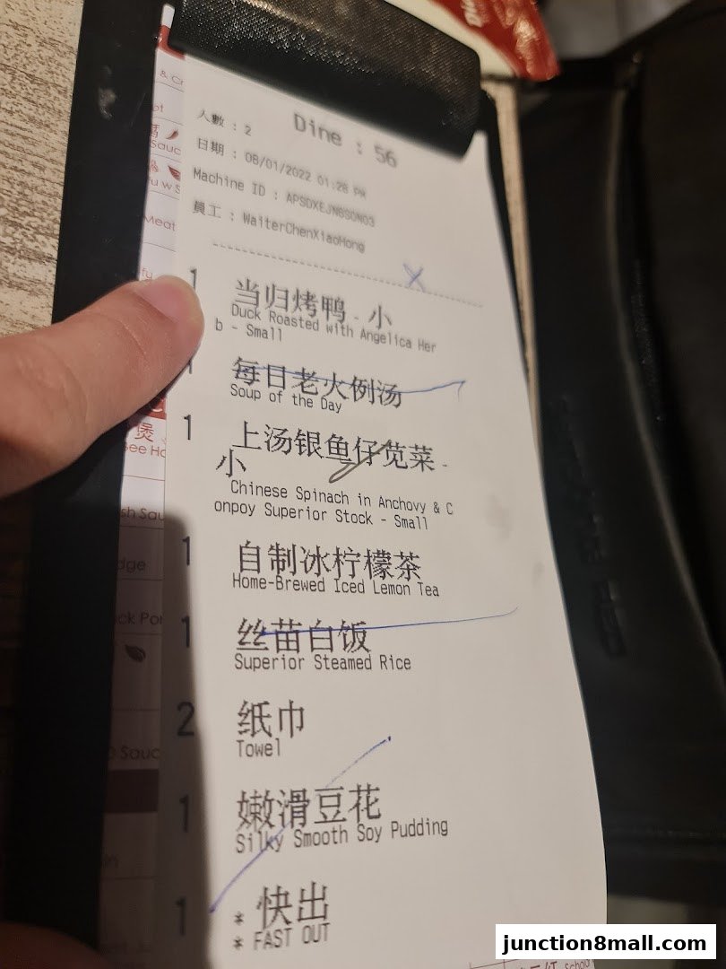 A close-up of a restaurant receipt showing various food and drink items ordered.