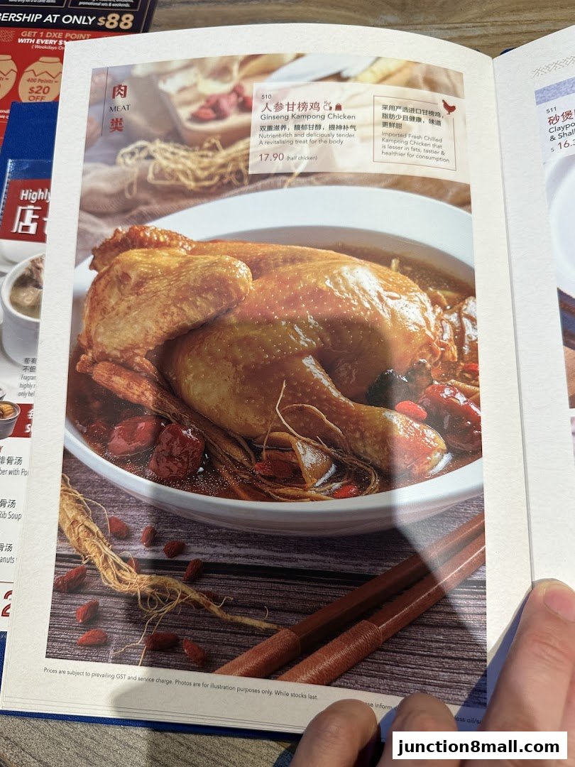 A close-up of a menu item featuring a whole roasted chicken in a savory broth with herbs.