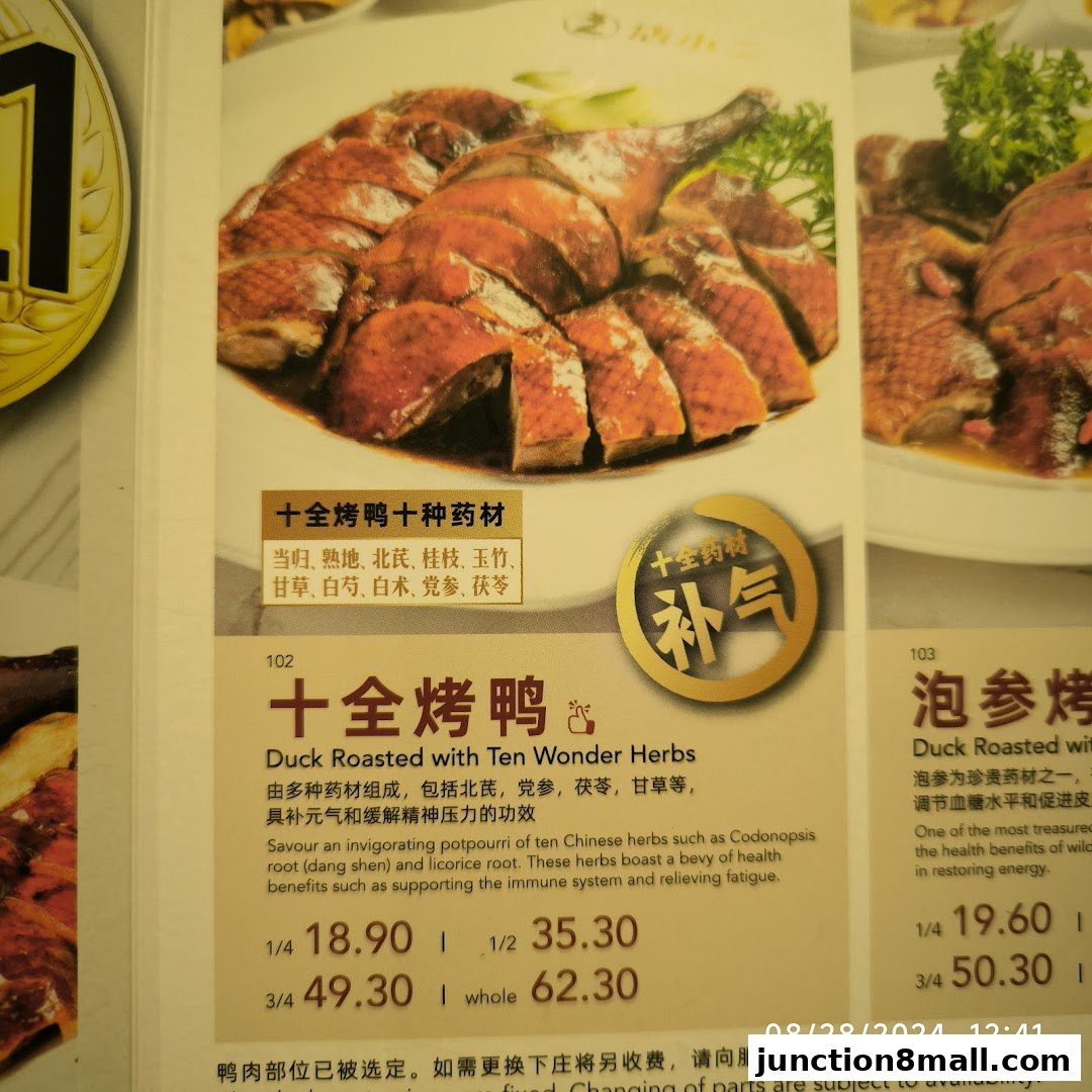 A close-up of a menu item featuring roasted duck with herbs and its description.