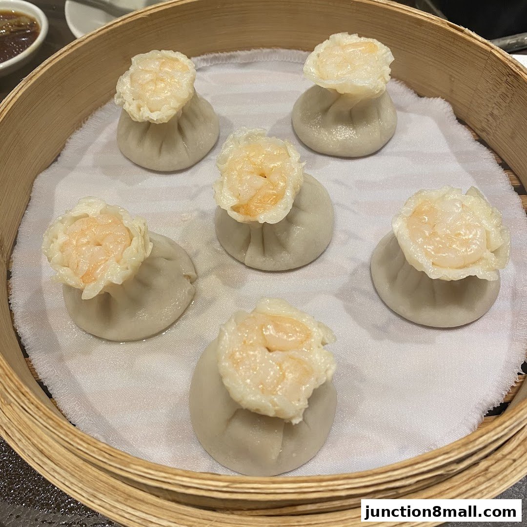 A close-up shot of six delicious shrimp dumplings served in a bamboo steamer.