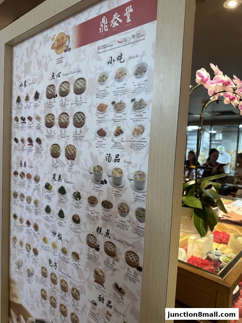 A menu board for Din Tai Fung restaurant showcasing various dumplings, snacks, soups, and more.