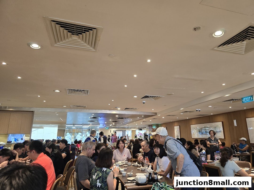 A busy restaurant interior with many diners seated at tables, enjoying their meals.