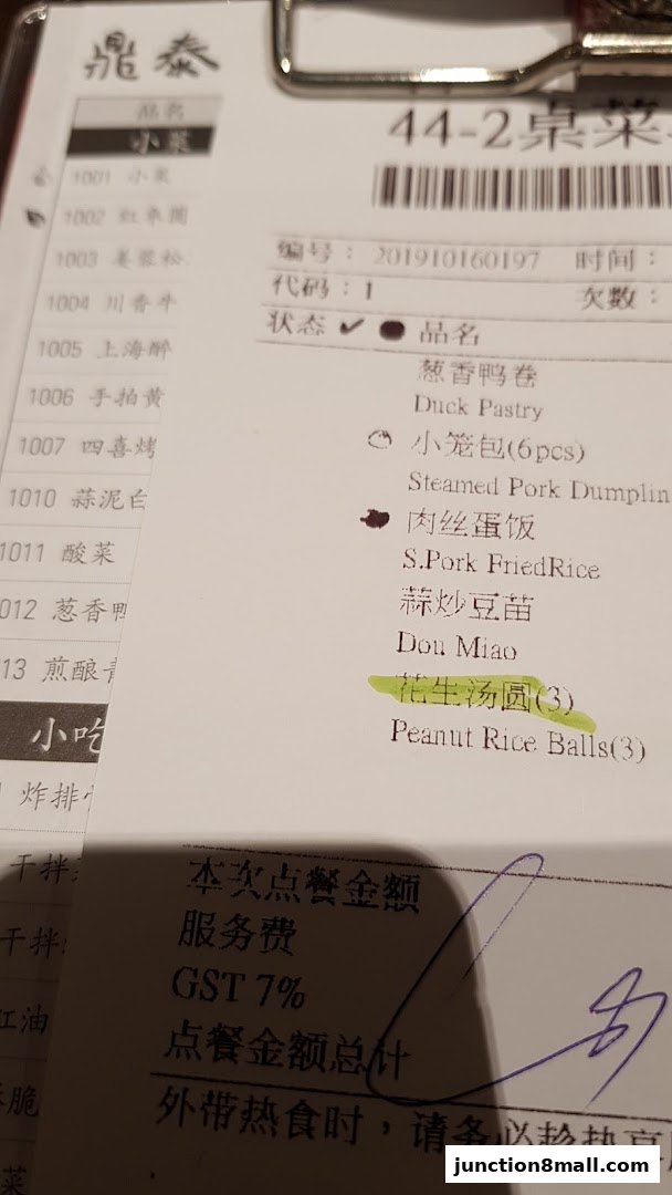 A close-up of a restaurant order slip showing various Chinese dishes and their English translations.